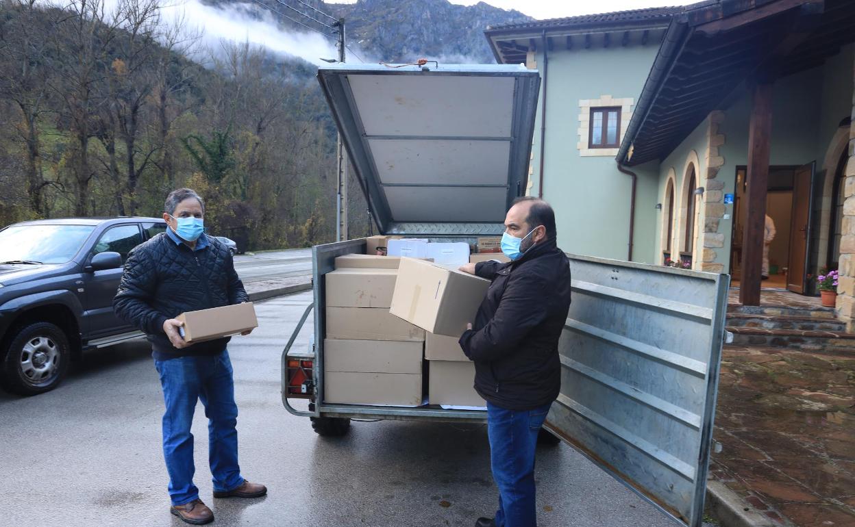 Oscar Casares y José Antonio Fernández, cargando el envío junto al Ayuntamiento de Camaleño 