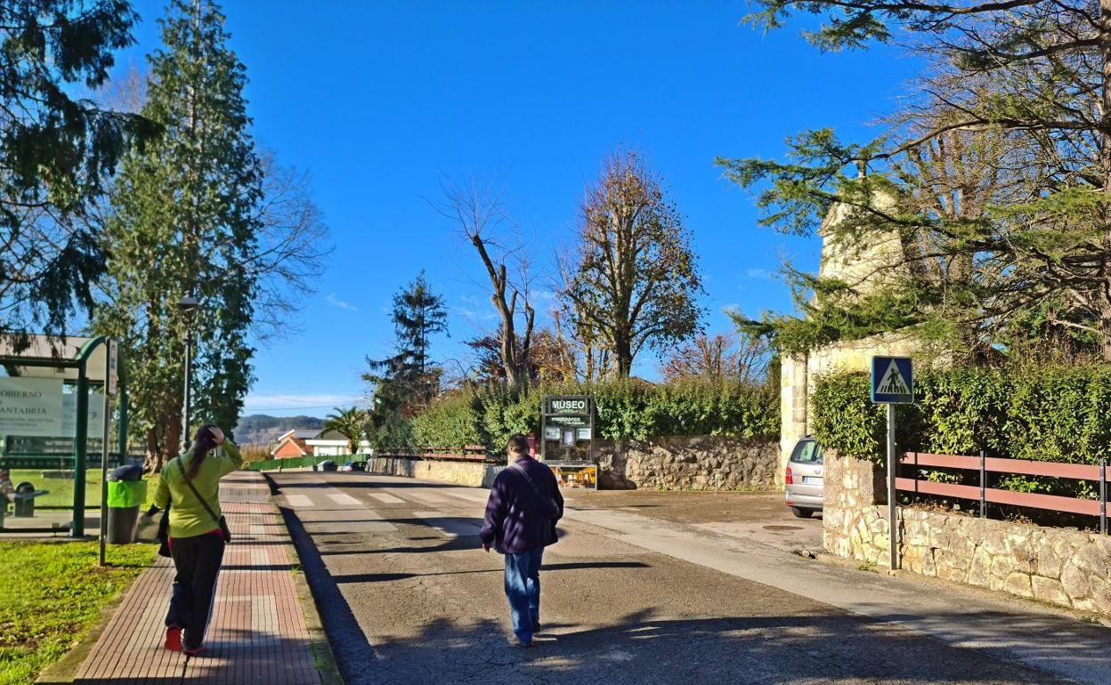 Dos paseantes caminan por la vía Héroes del 2 de Mayo, en Muriedas, junto al acceso del Museo Etnográfico de Cantabria, ayer, en Camargo