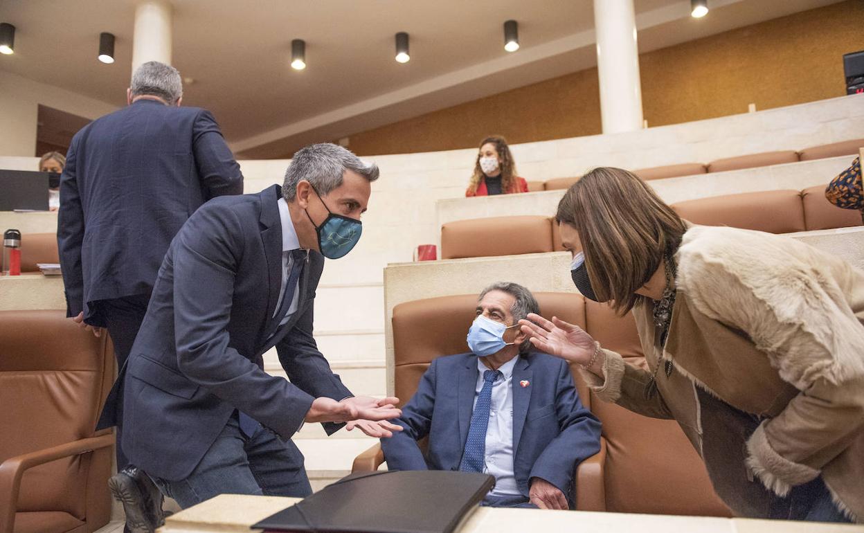 Pablo Zuloaga, ayer, en el Parlamento regional, dialoga con Paula Fernández frente a la atenta mirada de Miguel Ángel Revilla