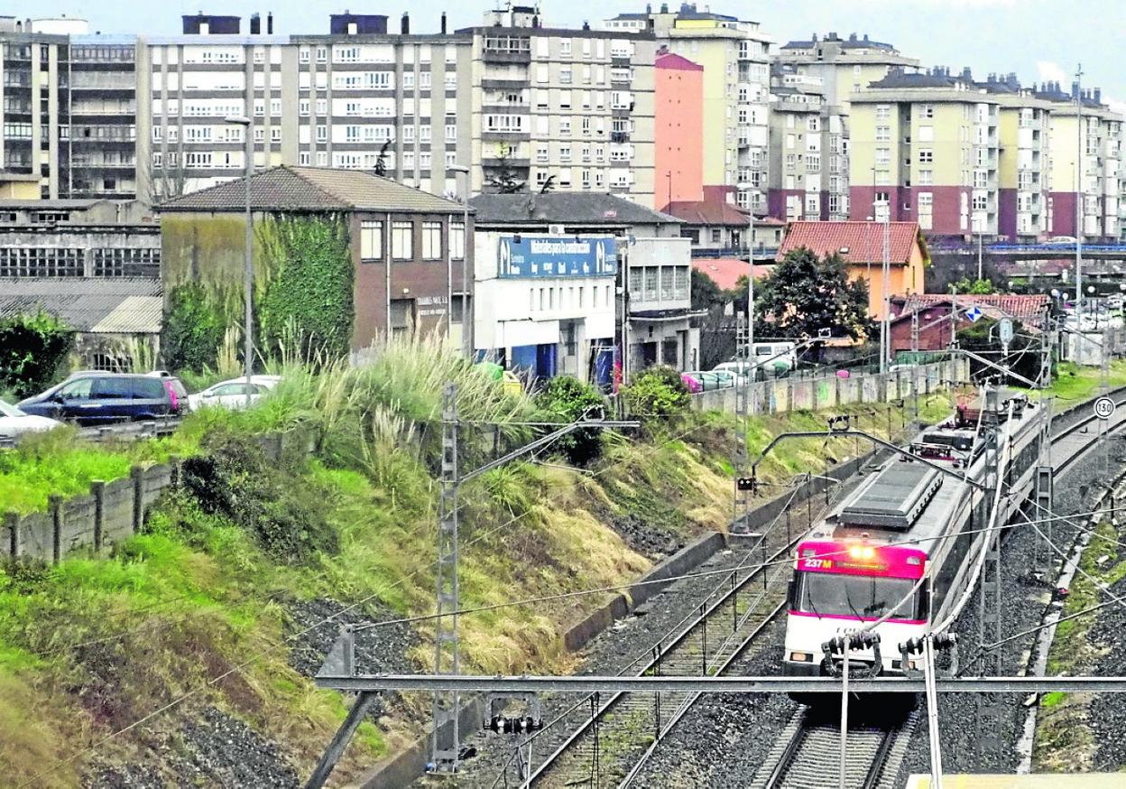 Un tren de Renfe a su paso por el casco urbano de Maliaño-Muriedas, en Camargo. 