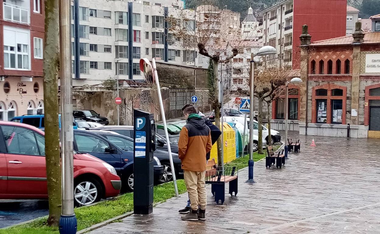 Dos jóvenes sacan un tique de aparcamiento en Castro.