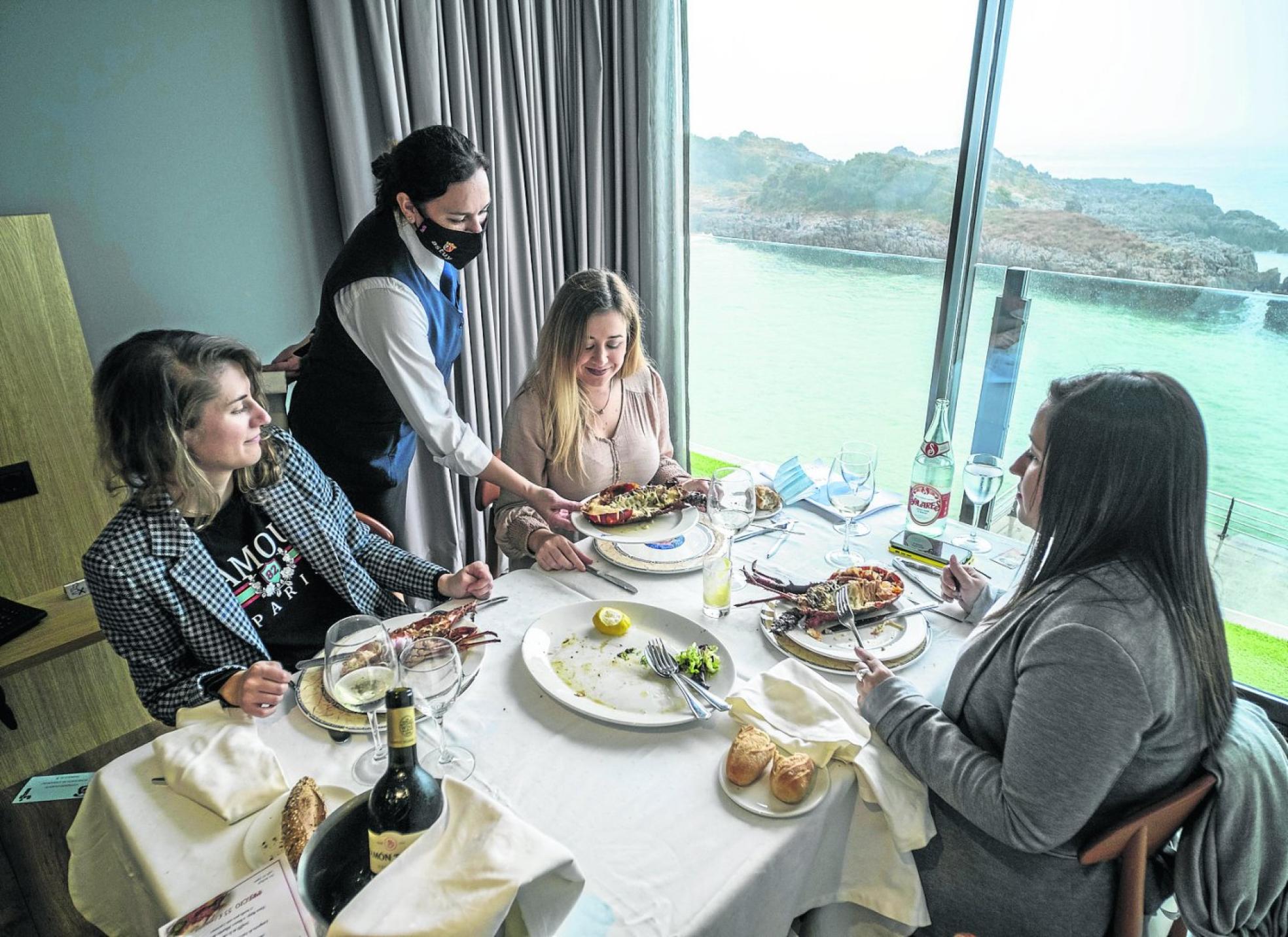 Ana María Cué, Marta Cabrera y Ana María Cagigas degustan langostas en la habitación-comedor privado.