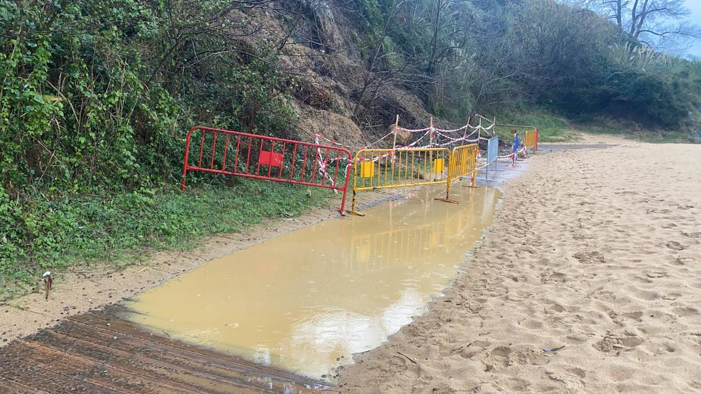 El paseo de El Sardinero está cubierto de agua y arena, mientras en la playa de Los Peligros aumenta el socavón bajo la pasarela de acceso y la lluvia forma una gran balsa en las inmediaciones del desprendimiento de Reina Victoria.