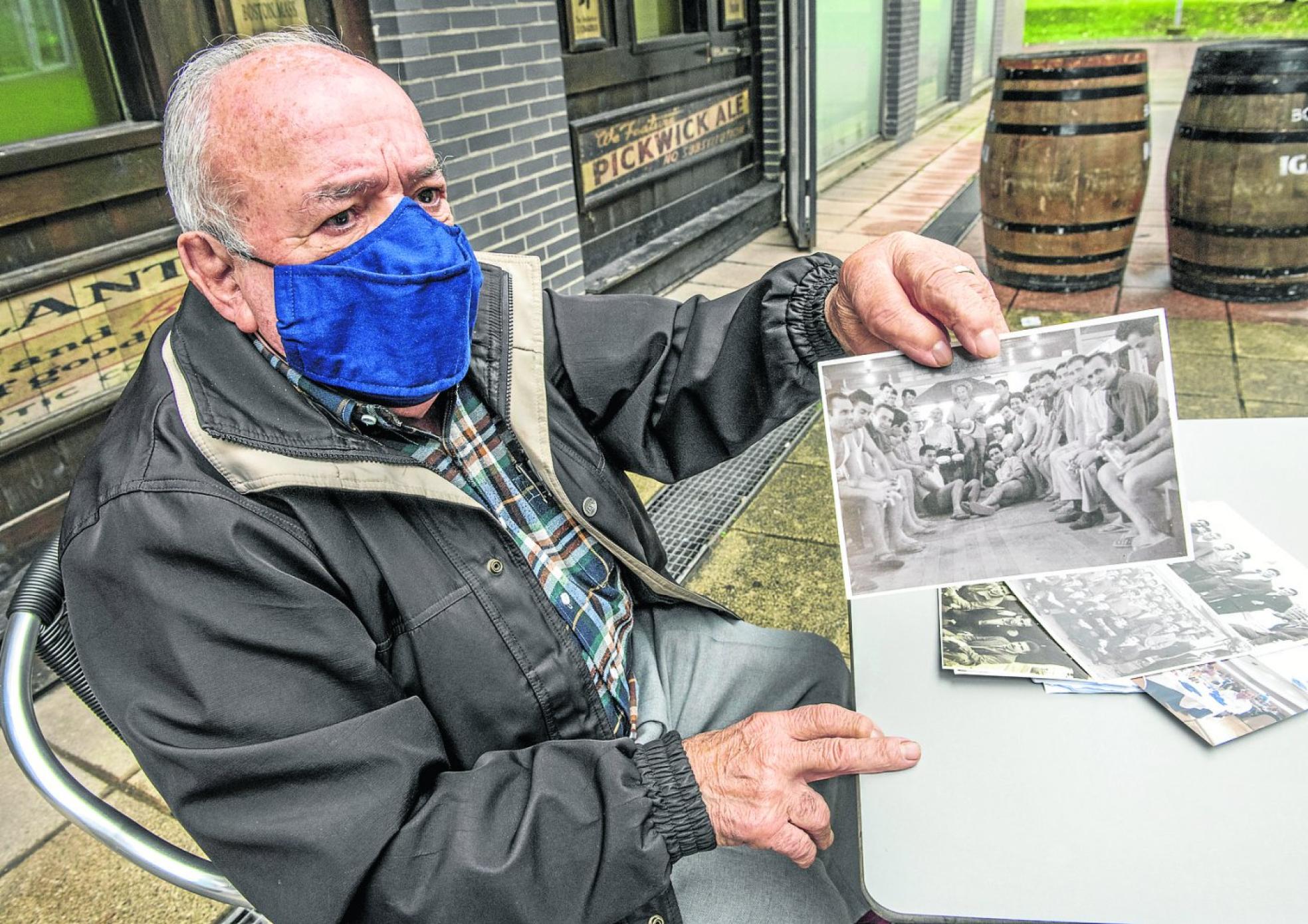 Fernando Sancho muestra una imagen suya con otros emigrantes en la bodega del buque Monte Udala durante el viaje. 