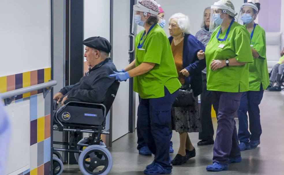 Las trabajadoras del CAD San Miguel,en Meruelo, acompañan a los usuarios a la sala de la residencia preparada para la vacunación. 