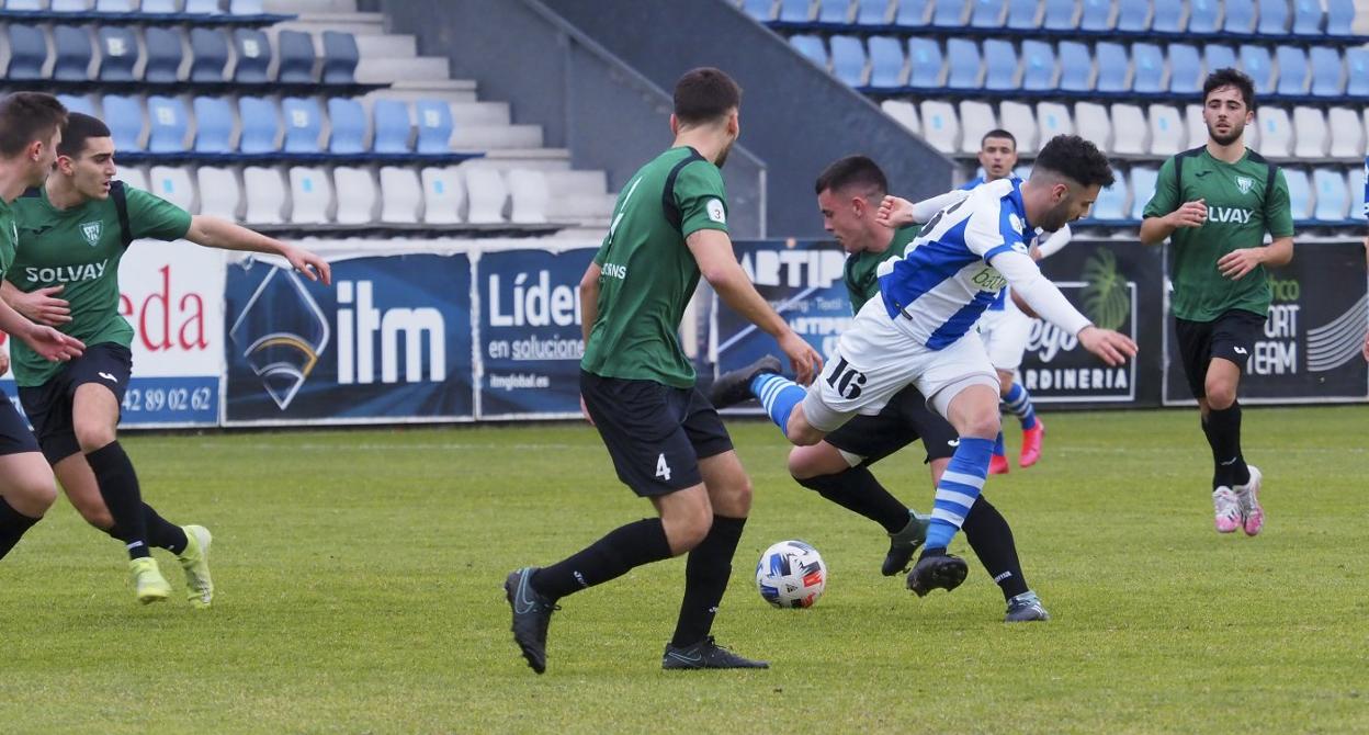 Borty, de la Gimnástica, y Álex Esteban, del Barreda, pugnan por el balón ante la mirada de Samu, del equipo de Solvay. 