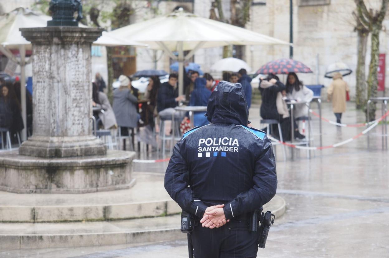 Un policía local supervisa la terraza de un negocio de hostelería.