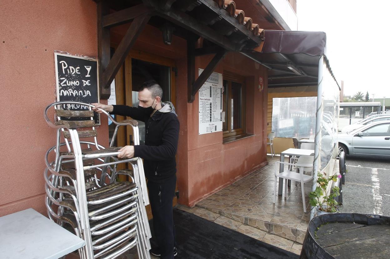 Javier apila sillas en la terraza del restaurante Palacios. 