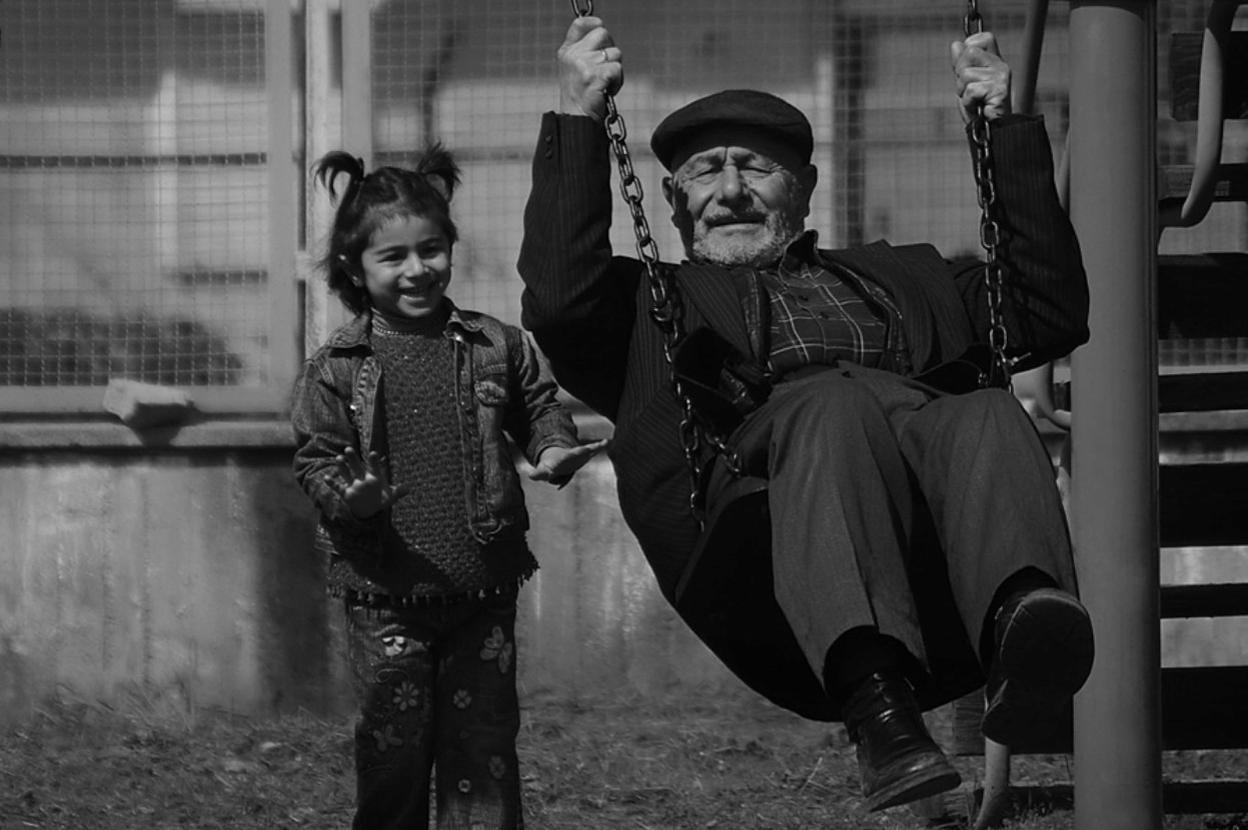 Abuelo en el columpio jugando con su nieta.