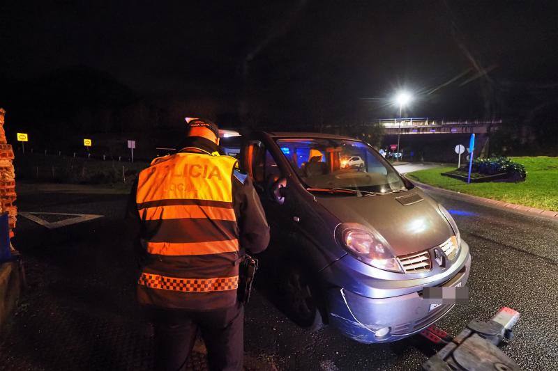 Agentes de la Policía Local inspeccionan la furgoneta después de detener a su conductora en la rotonda de Solares, donde se estrelló, tras una persecución desde Santander.