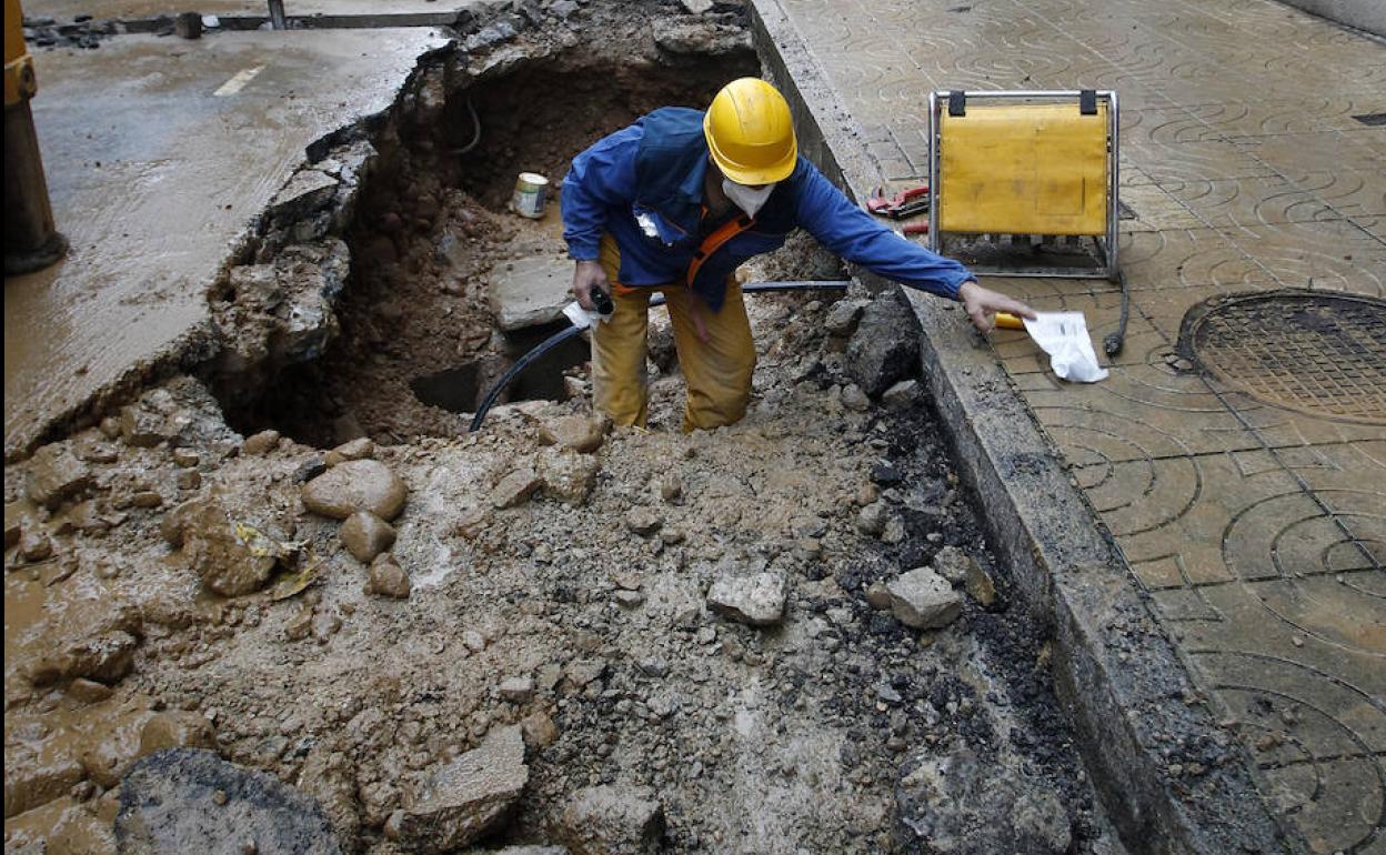 Un operario trabaja en el socavón de la calle Ruiz Tagle para dar con el origen de la fuga de agua.