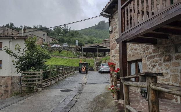 Un tractor recorre Tresviso, por calles prácticamente vacías.