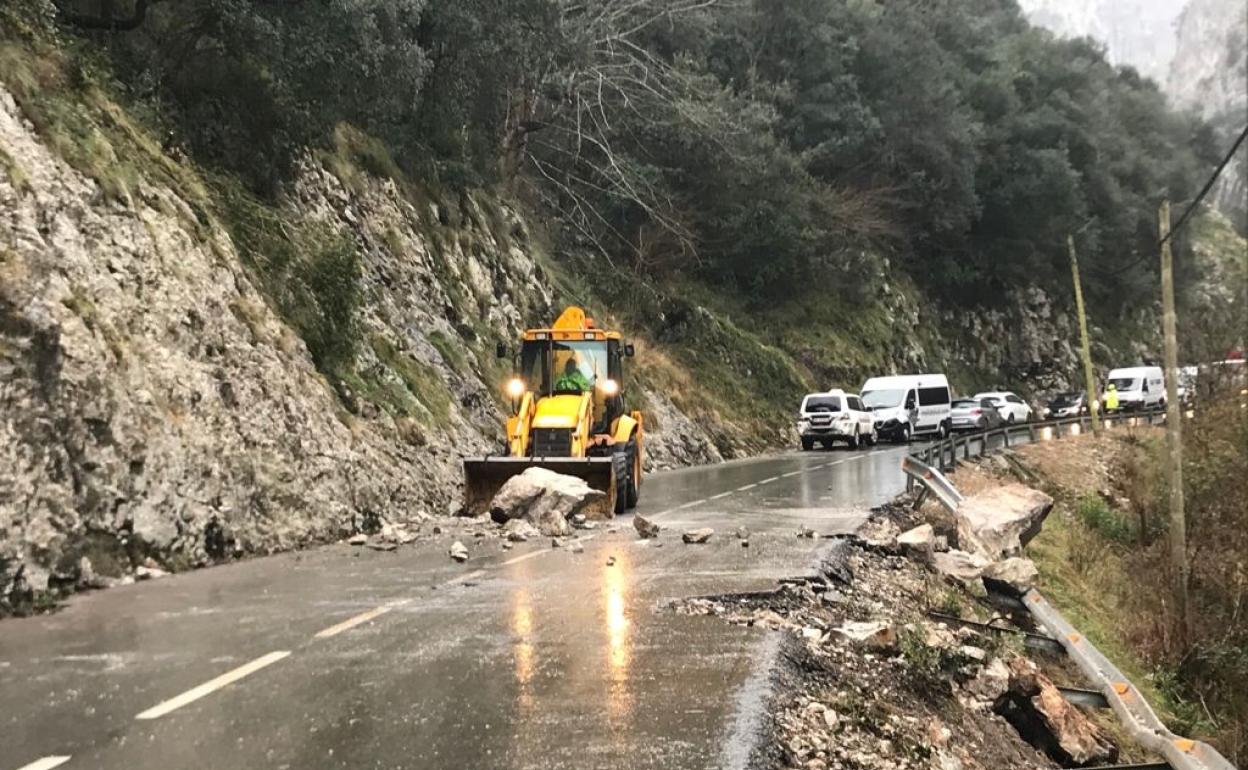 Una pala mixta de Carreteras retira las piedras caídas