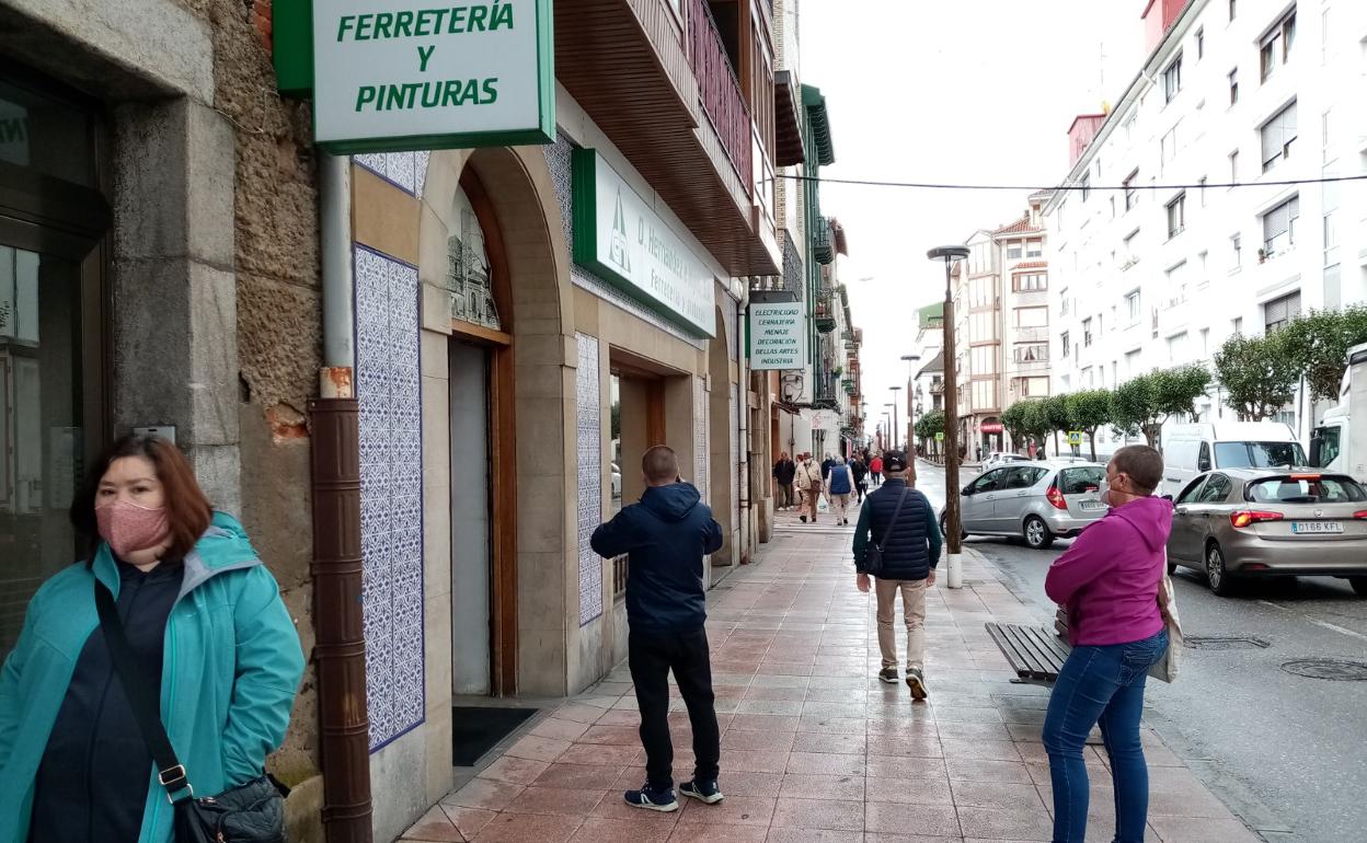 Ciudadanos esperando para entrar en un comercio castreño.