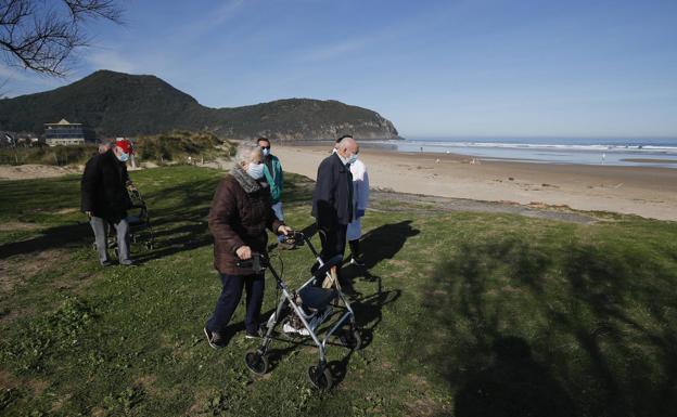 Carmen Arbaiza y Mauricio Pérez, con la educadora social Marta González. Detrás, Domingo Celaya, Fidel Berrire y Enrique Ruiz, este miércoles, en la playa de Berria. 