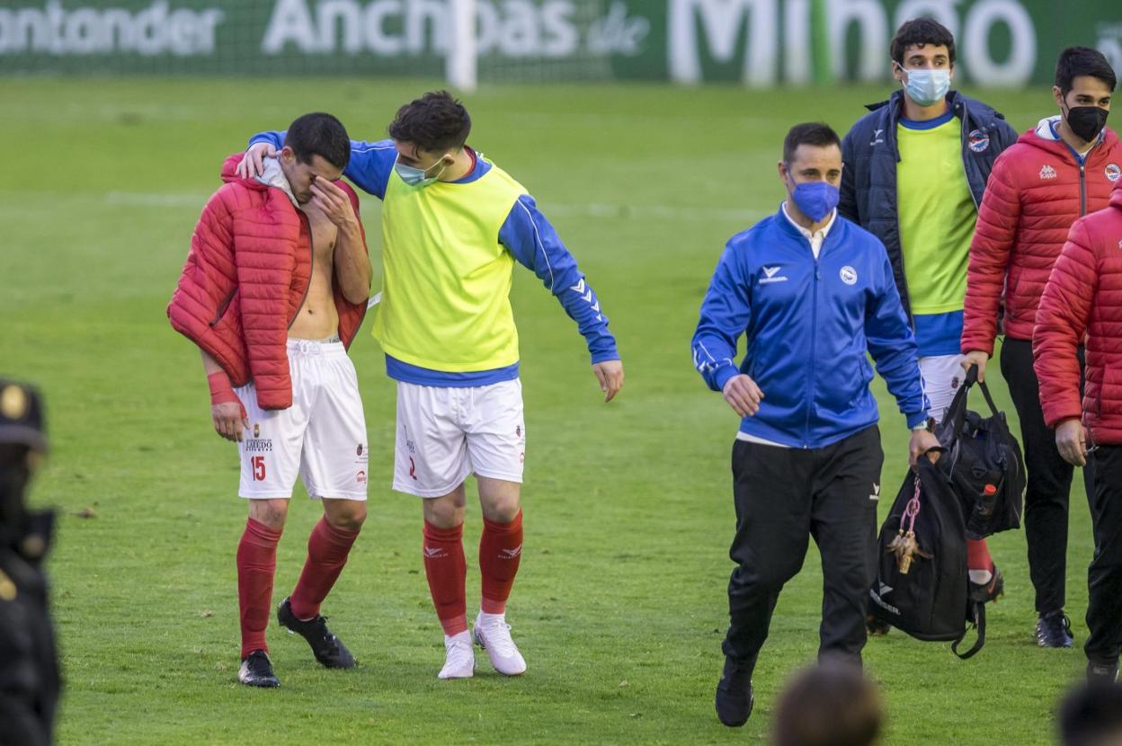 Juancar consuela al lesionado Diego Marta a su salida del césped de los Campos de Sport tras su lesión.