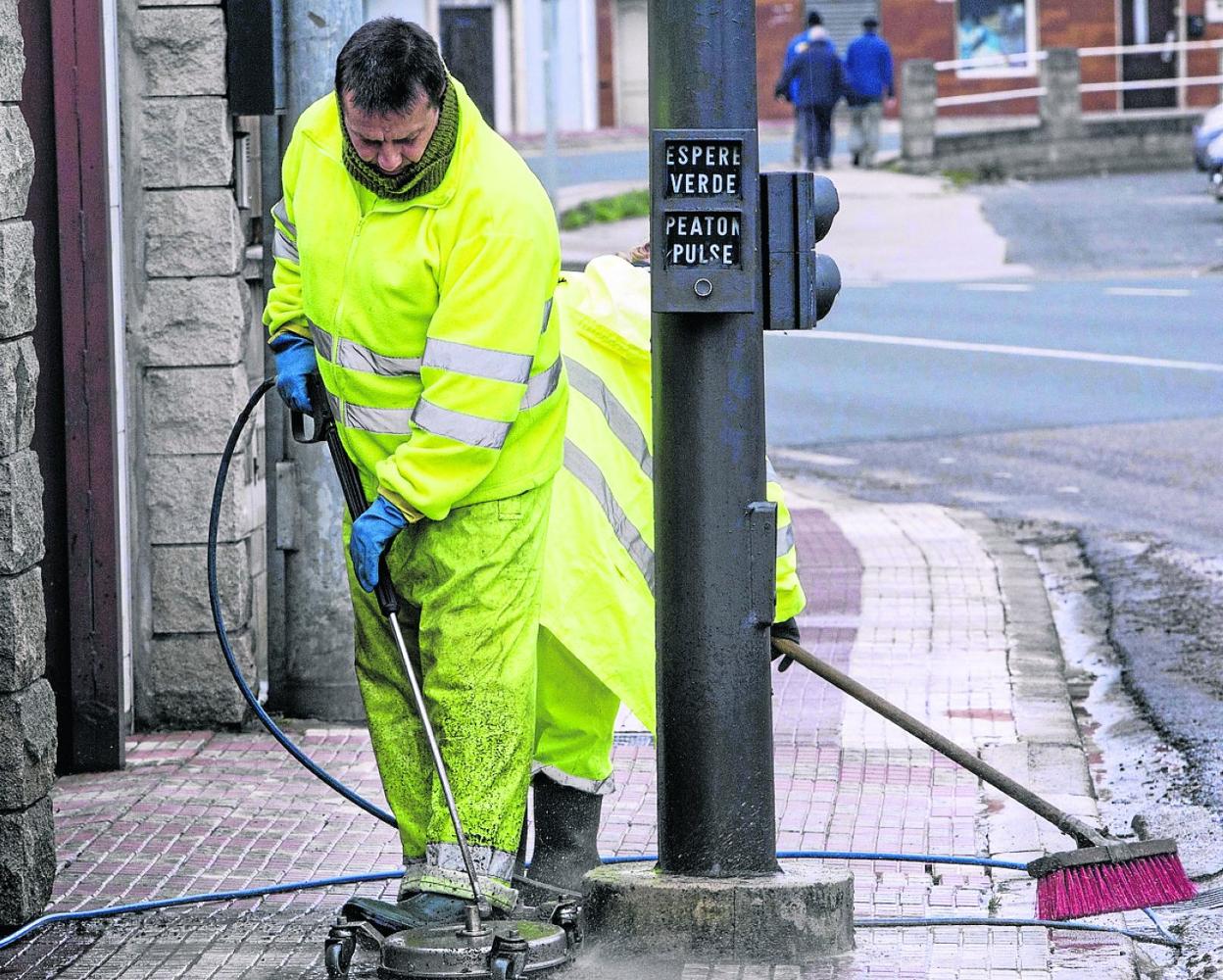 Dos operarios del servicio de limpieza viaria trabajan sobre una acera de Camargo, en una imagen de archivo.