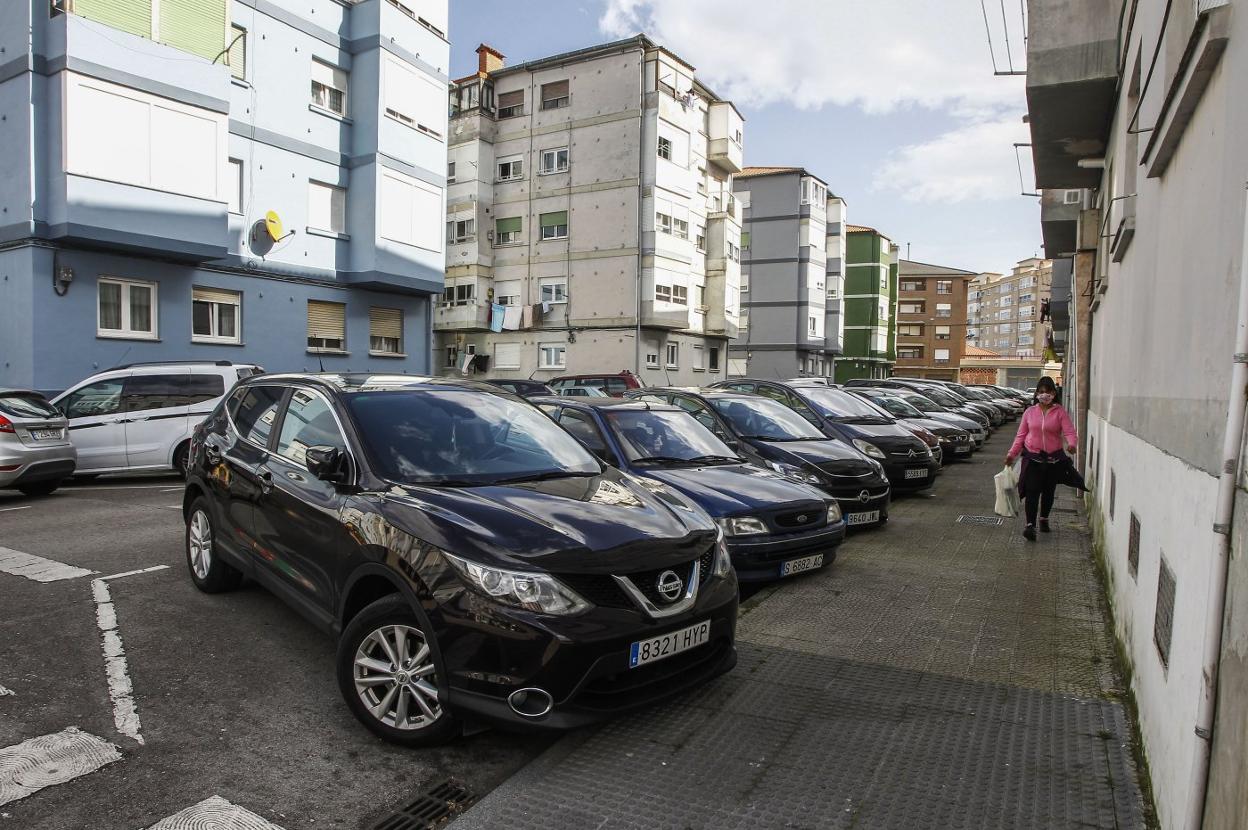 Vehículos estacionados en batería en una de las calles del Barrio Covadonga incluida en el proyecto de urbanización. 