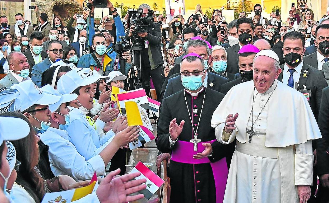 Bergoglio es recibido por un grupo de niños a su llegada a la catedral de Bagdad.