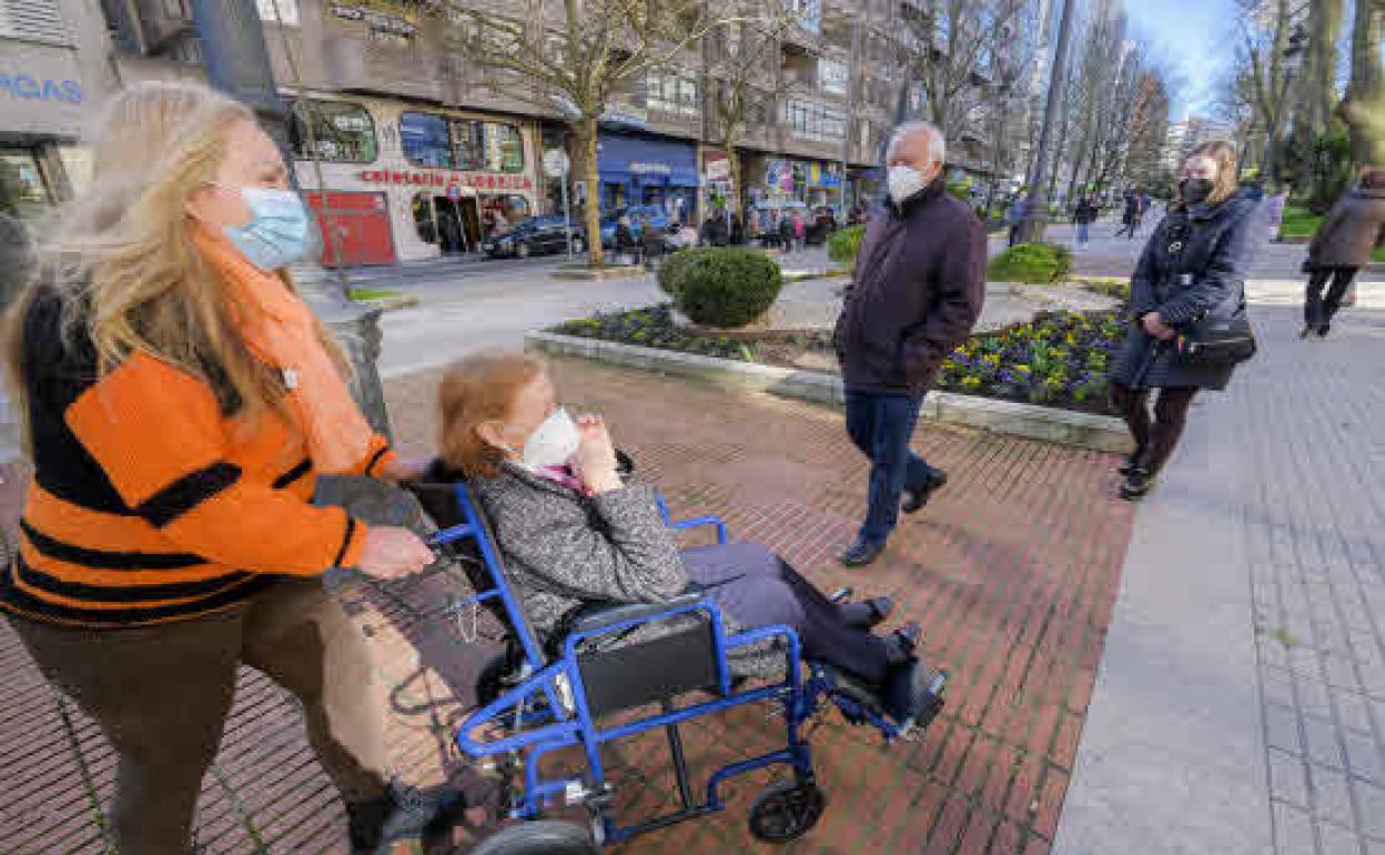 Una mujer acompaña a una anciana a recibir la vacuna a un centro de salud en Santander