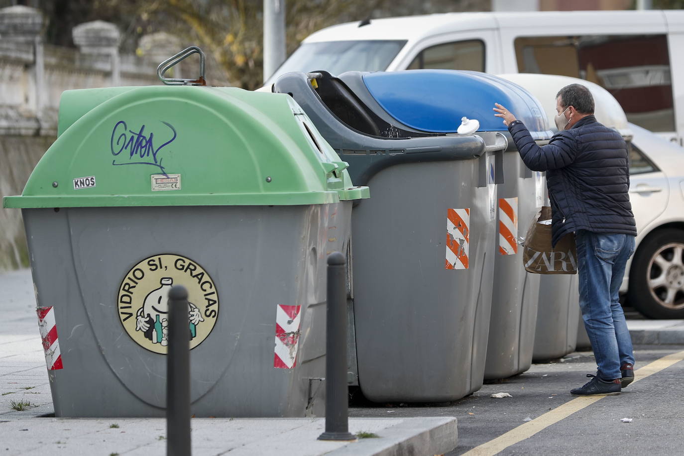 Un vecino de Santander hace uno de los contenedores de basura. 