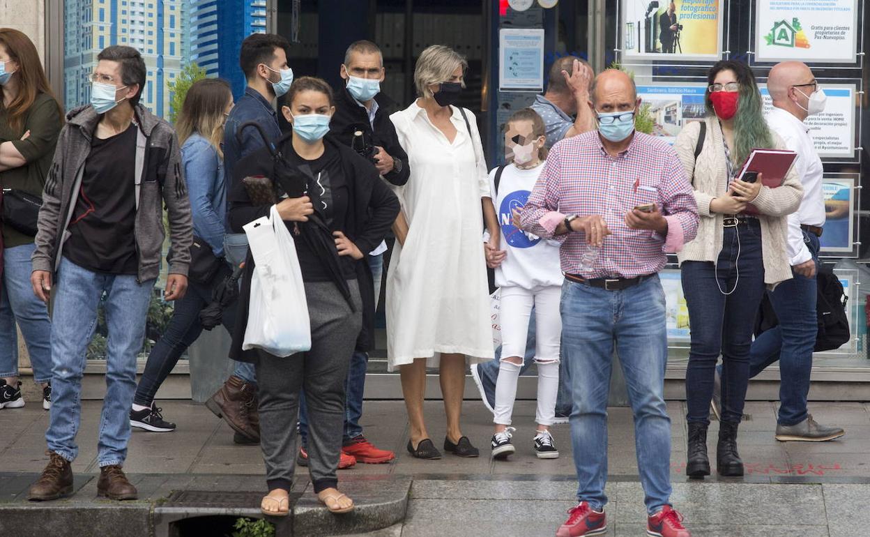 Un grupo de personas con mascarillas, en una calle de Santander.