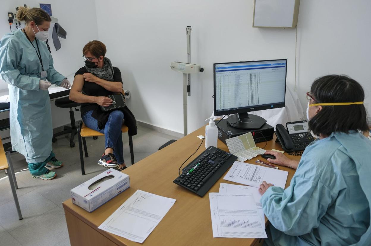 Una trabajadora se vacuna en el centro de salud de Cayón el día que empezó la campaña de AstraZeneca entre el personal docente. 