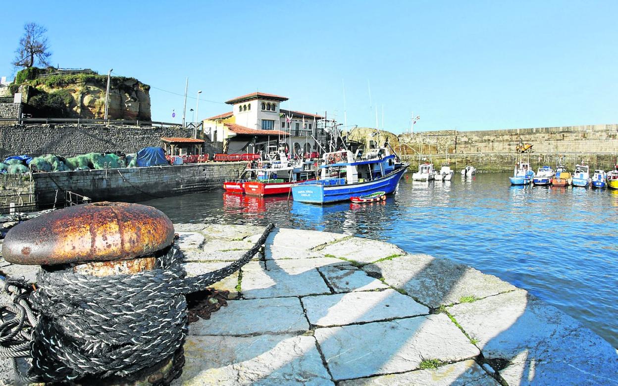 El puerto de Comillas, con barcos de pesca en primer plano y algunos de recreo al fondo. 