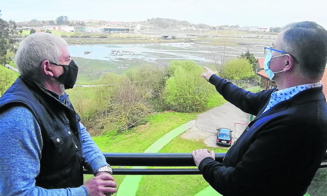 Dos vecinos afectados por los ruidos señalan el puente de hierro sobre el que cruza el tren. 