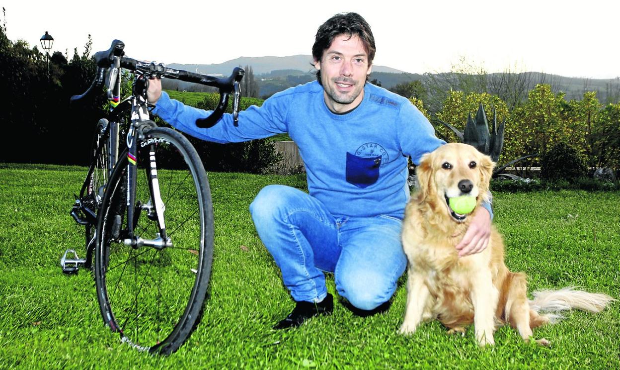 El exciclista Óscar Freire posa con Dora, su Golden retriever, en el jardín de su casa. 