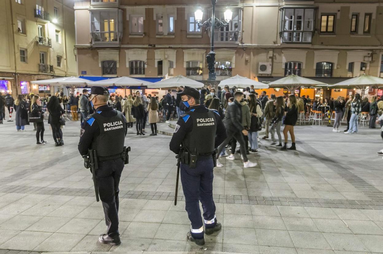 Dos agentes de la Policía Local vigilan desde la distancia la plaza de Cañadío. 