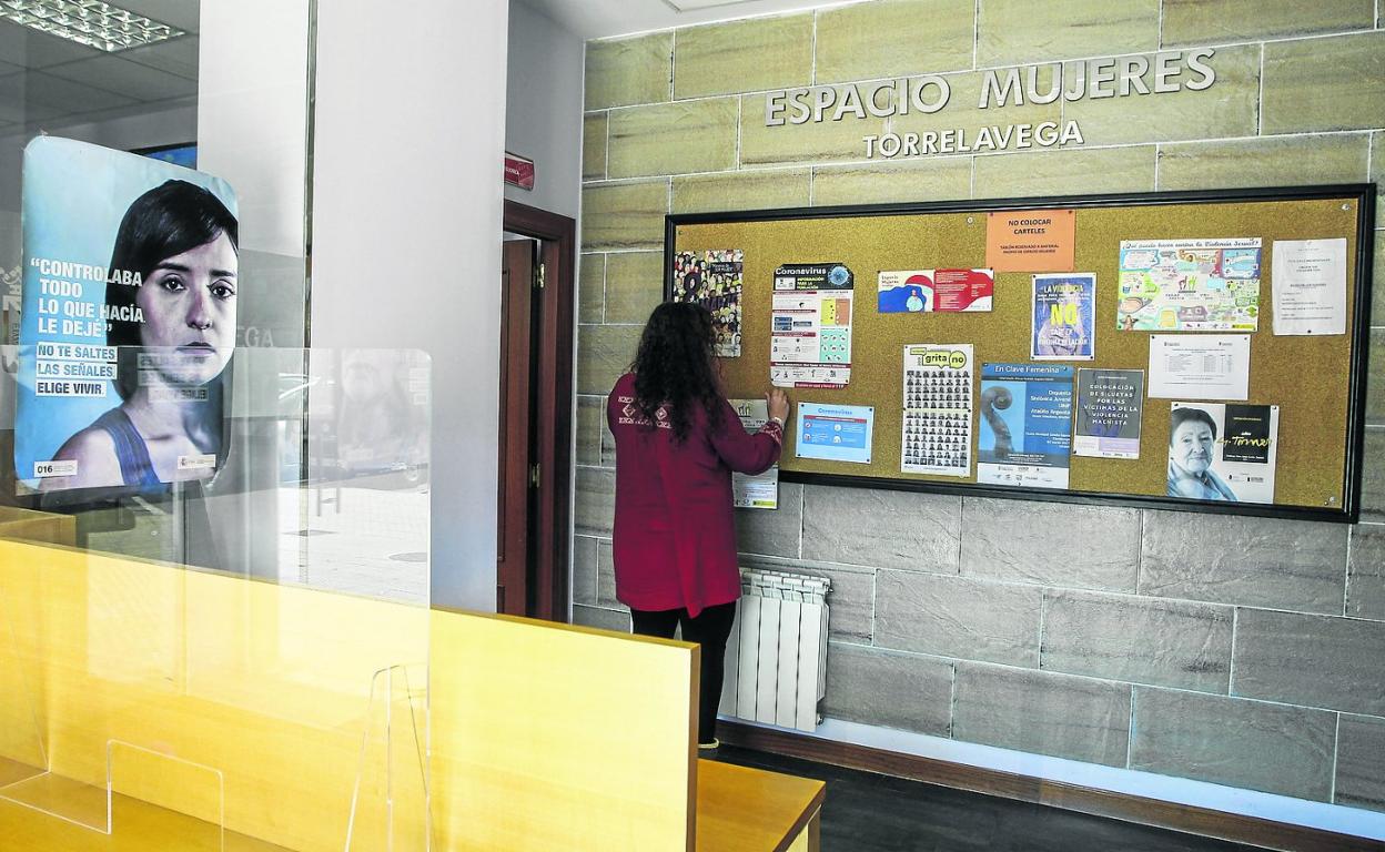 Una mujer observa un panel informativo en el Centro Municipal de Igualdad, Espacio Mujeres, de Torrelavega. 
