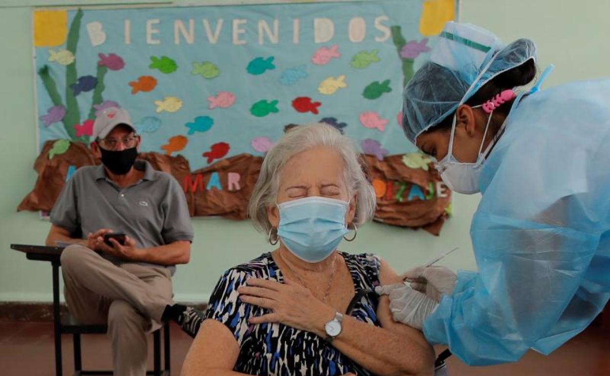 Una sanitaria vacuna a una mujer. 