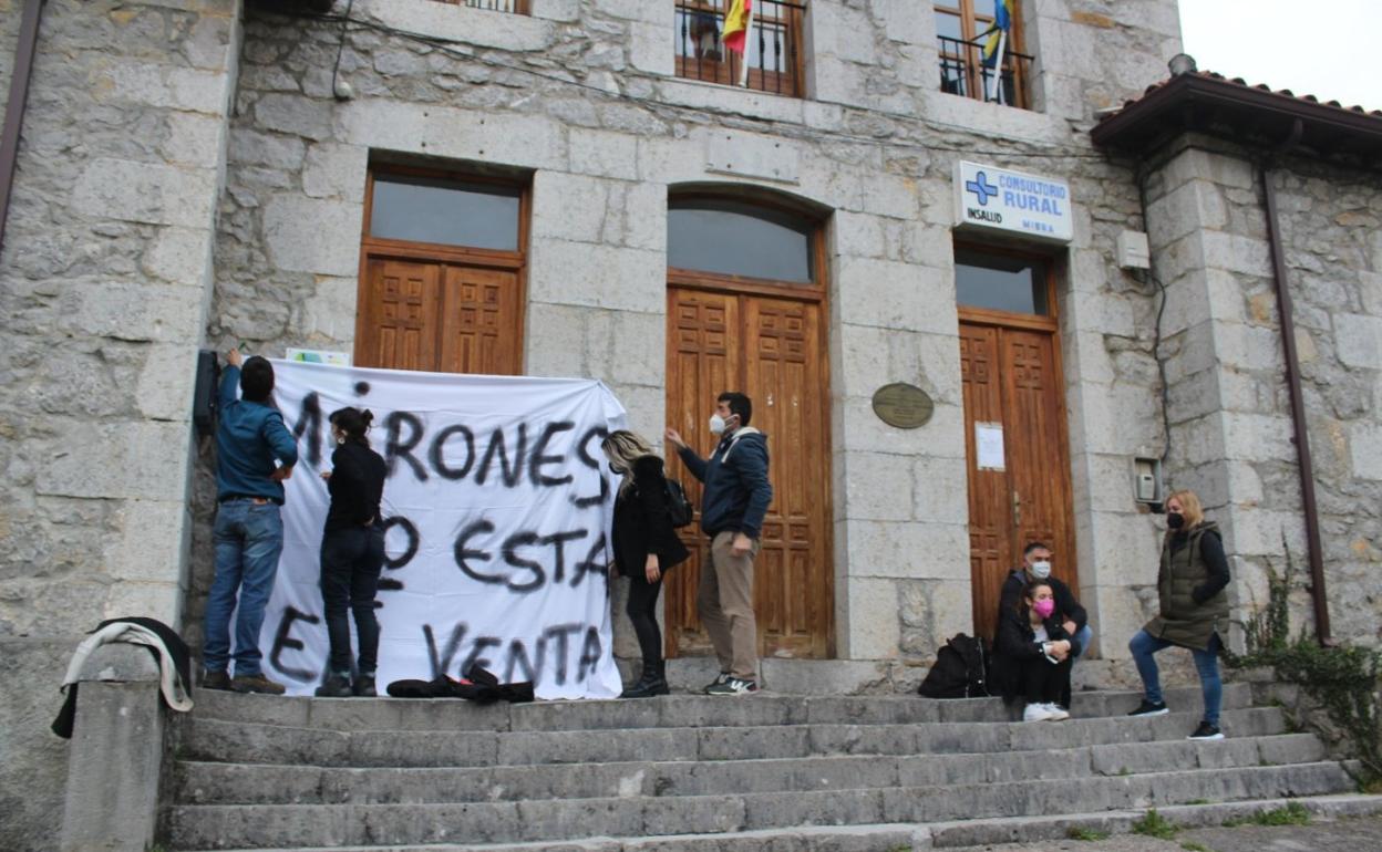 Varias personas colocan una pancarta contra el parque de Garma Blanca en el pueblo de Mirones (Miera).