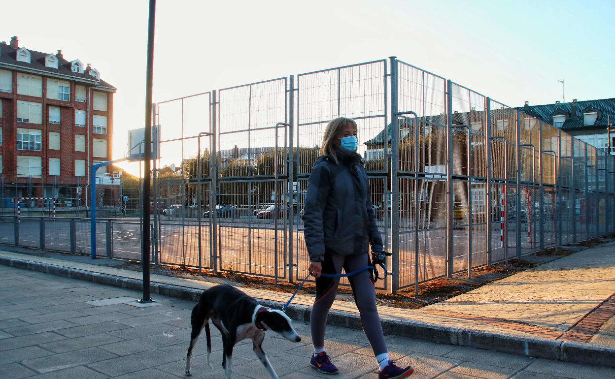 Una mujer pasea con su perro por la actual plaza de Somo, que será completamente reformada 