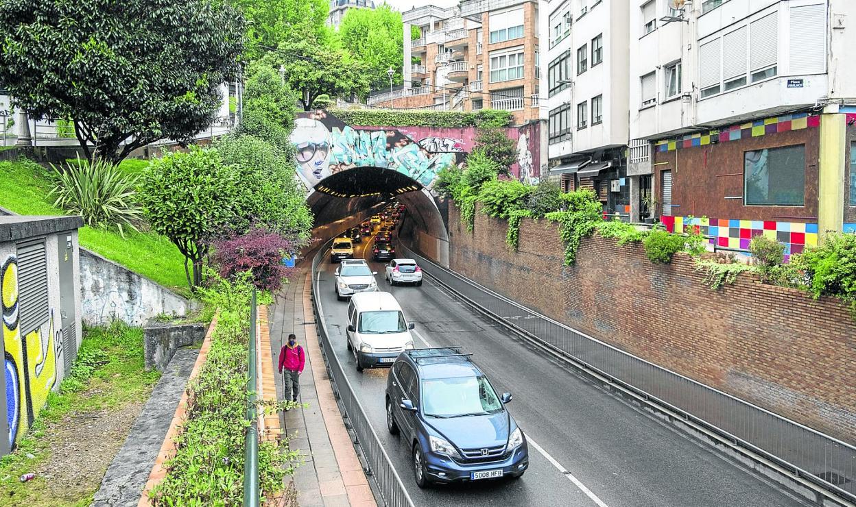 Imagen actual de la boca del túnel, con el paso de vehículos por la carretera, una acera para peatones y otra para ciclistas. 