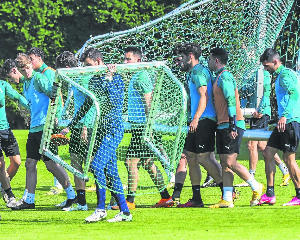 Los jugadores del Racing cargan con una portería en un entrenamiento. 