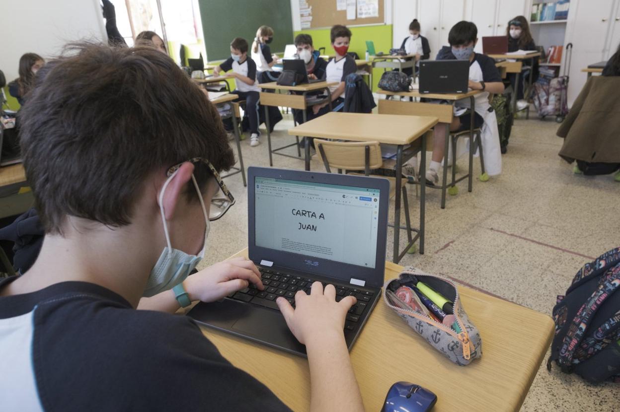 Un grupo de alumnos utilizan sus ordenadores en una clase. 