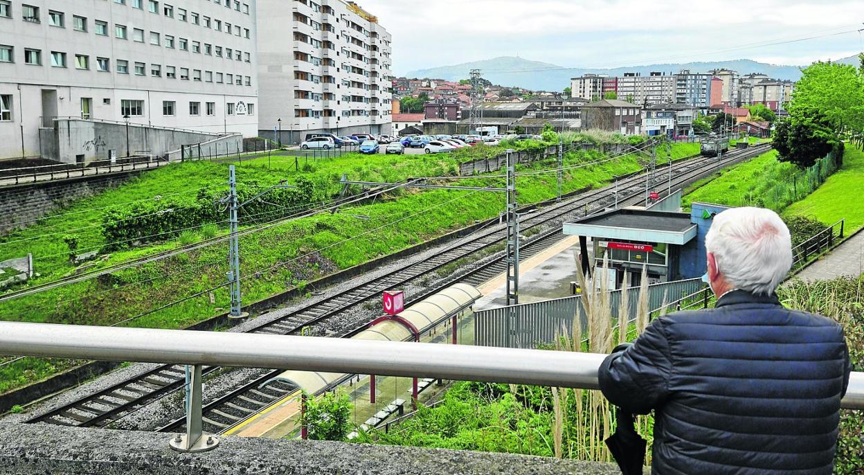 Un vecino del casco urbano de Maliaño-Muriedas se detiene ante las vías de tren a su paso por el centro, esta semana, en Camargo.