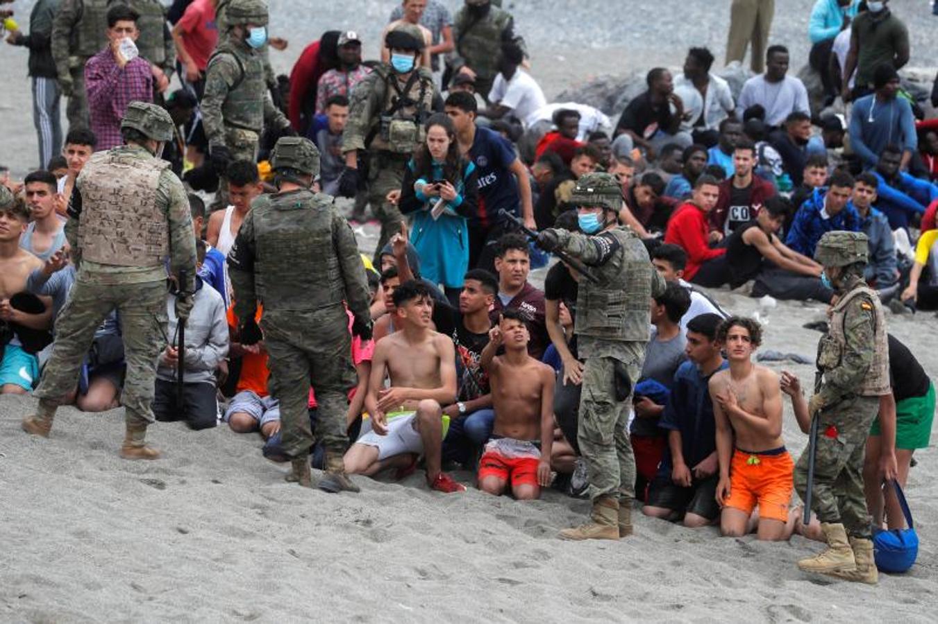 Miembros del Ejército reagrupan a los menores en la playa El Tarajal, cerca de la valla entre la frontera hispano-marroquí.