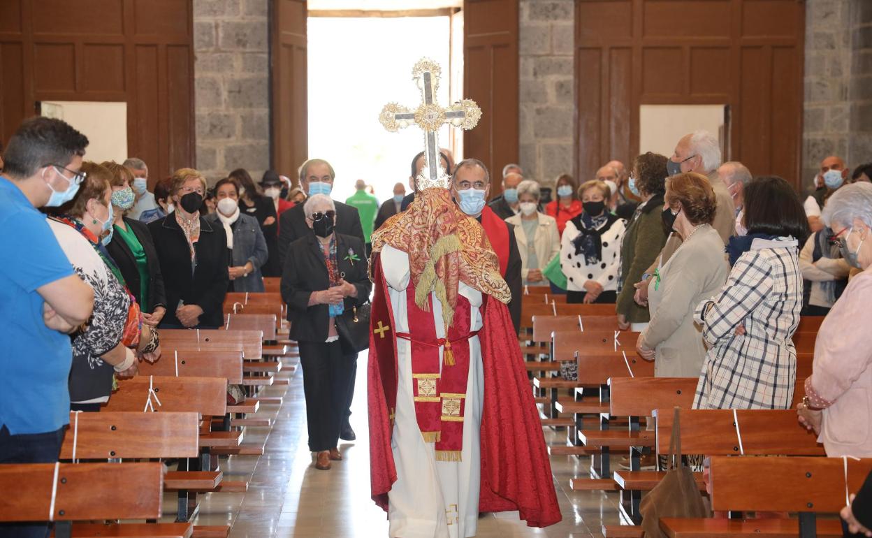 El párroco Elías Hoyal porta el Lignum Crucis entrando en la iglesia parroquial de Potes 