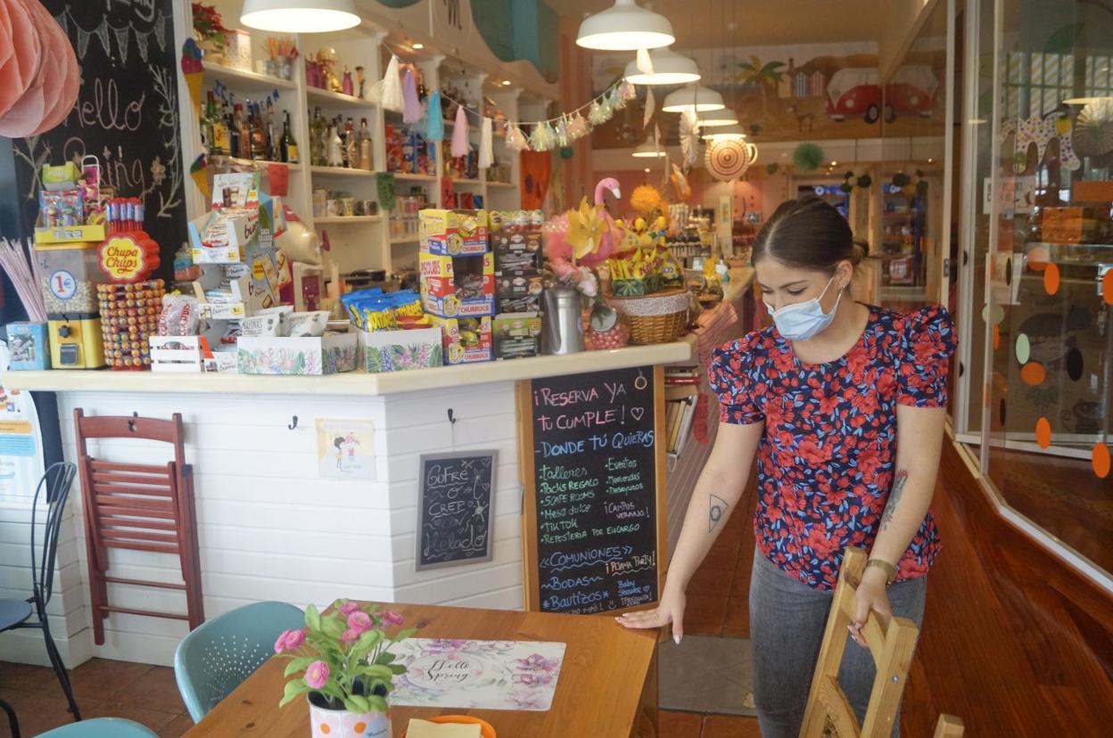 Estela ordena las mesas y sillas con distancia de seguridad. 