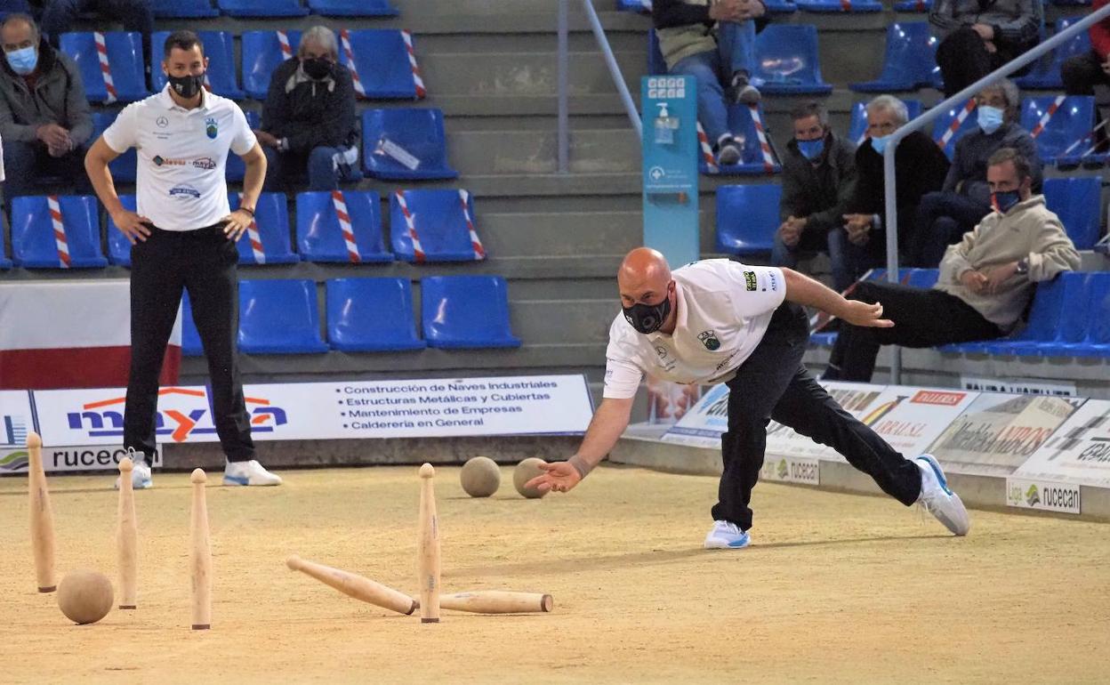 Salmón al birle durante el partido de ayer ante la mirada de Víctor González. Al fondo, sentado, Raúl de Juana, jugador de Borbolla