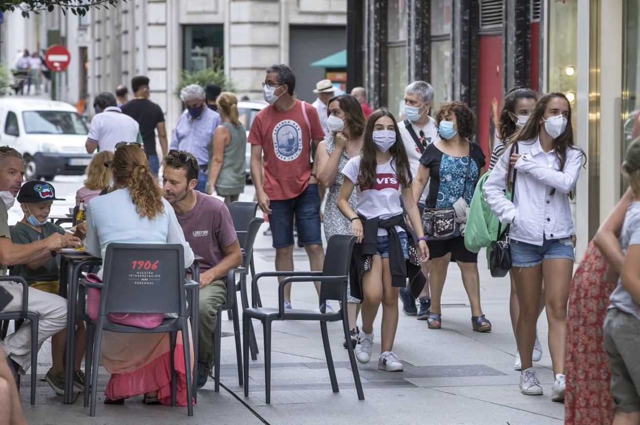 Varias personas pasean por delante de las terrazas de la calle Juan de Herrera de Santander. 