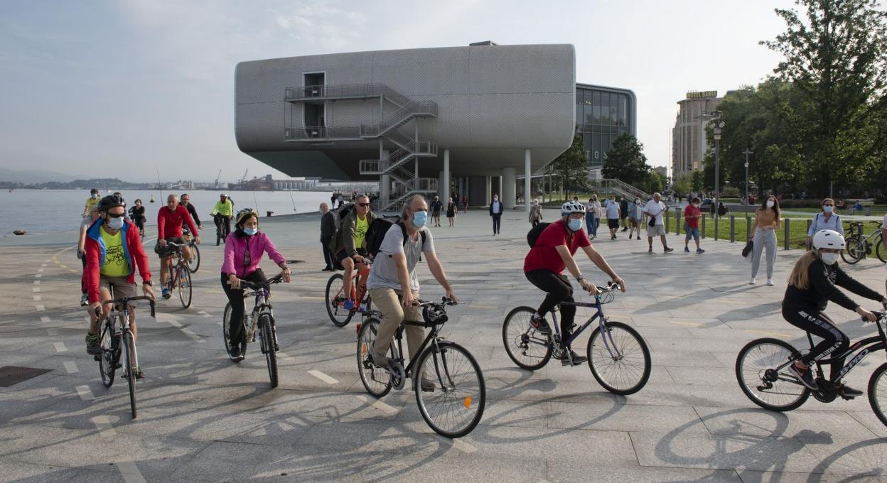 Un grupo de ciclistas recorre el carril bici que transcurre junto al Centro Botín y la Grúa de Piedra, en el centro de Santander. 