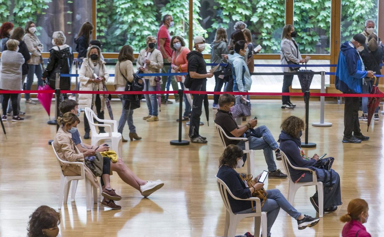 La gente espera sentada los quince minutos tras el pinchazo, mientras otro grupo hace cola para pincharse, ayer, en el Palacio de Exposiciones. 