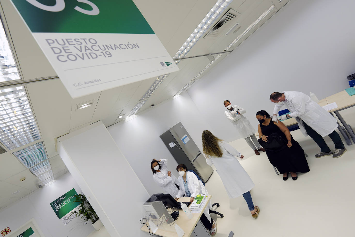 Una sanitaria inocula la vacuna a una mujer en el Centro de Vacunación de El Corte Inglés de Arapiles, en Madrid.