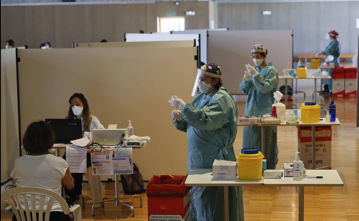 El personal sanitario prepara los viales en la primera jornada de vacunación en el Palacio de Exposiciones de Santander. 