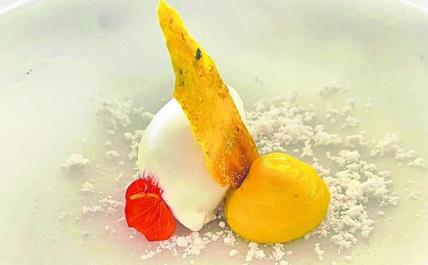 Imagen. Postre gastronómico. Se llama Lassi y recuerda a una bebida tradicional de la India hecha a base de yogur. Aquí el chef la deconstruye y la transforma en un postre creativo. La base es una tierra de coco a la que se suman la cúrcuma y el mango formando una crema, el azafrán en el crujiente y completa el conjunto un helado de yogur. 