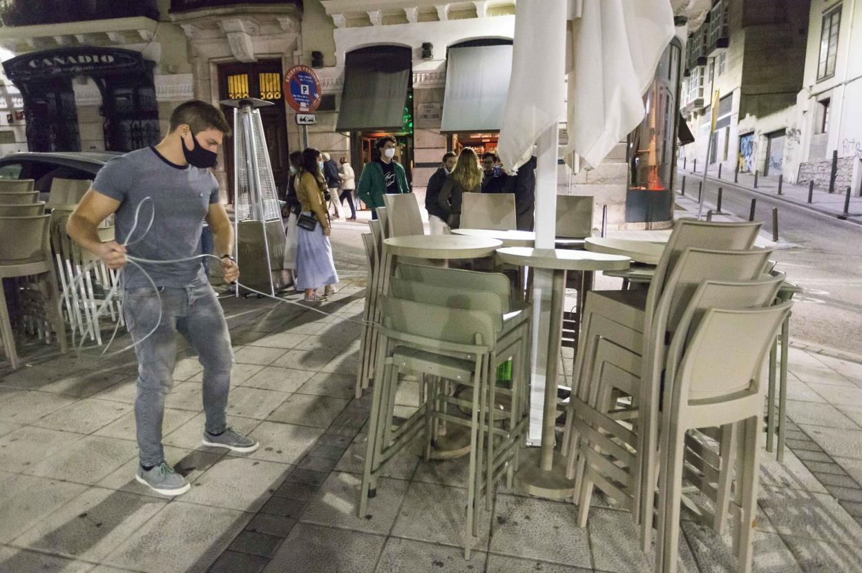 Un hostelero recoge la terraza de su establecimiento en la Plaza Cañadío de Santander. 